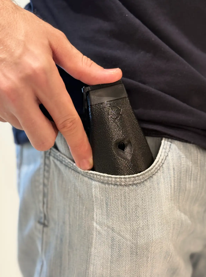 Imagem mostra uma ocarina da Nomad dentro do bolsa de uma calça jeans